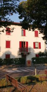 un edificio con finestre rosse e una panca di fronte ad esso di B&B I COLLI DI BERGAMO ALTA a Bergamo
