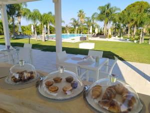 twee borden gebak op een tafel naast een zwembad bij Tenuta Espada Luxury Residence in Gallipoli