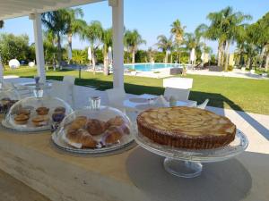 - une table avec deux assiettes de pâtisseries et une tarte dans l'établissement Tenuta Espada Luxury Residence, à Gallipoli