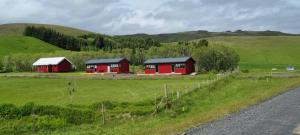 dos cabinas rojas en un campo al lado de una carretera en New and well furnished studio apartment for two 30 km from Kirkjubæjarklaustur Perfect place to stay at right between Black beach and Jökulsárlón, en Kirkjubæjarklaustur