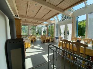 a conservatory with tables and chairs and windows at Pension-Ferienwohnung Liesbachtal direkt am Waldrand Bayerische Rhön in Schönau an der Brend +47 photos