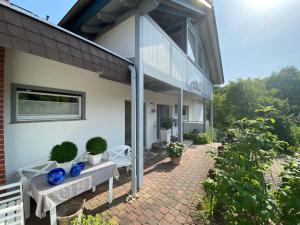 a patio of a house with two benches and plants at Pension Liesbachtal direkt am Waldrand Bayerische Rhön in Schönau an der Brend