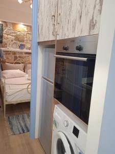 a kitchen with a washer and dryer in a room at Artistic house in Kokkari