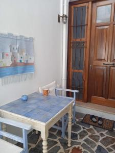 Una mesa en una habitación con suelo de baldosa azul en Artistic house en Kokkari