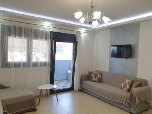 Una sala de estar con un sofá y una ventana. en Iros Apartment, en Nea Peramos