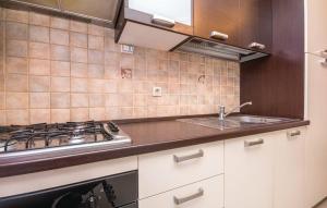 a kitchen with a stove and a sink at Apartmani Andrija in Pakoštane