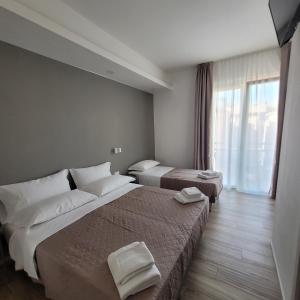 Cette chambre comprend 2 lits et une fenêtre. dans l'établissement SOMA, à Rimini