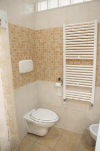 a bathroom with a toilet and a window and a sink at Respice Stellam casa vacanza in Castellaneta