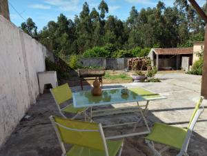 a patio with chairs and a table with a glass top at Casa Júlia in Fonte Errada