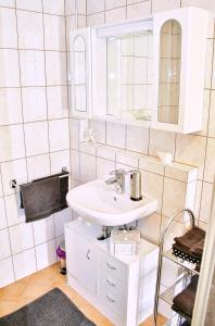 bagno bianco con lavandino e specchio di Ferienhaus Possath a Leutschach