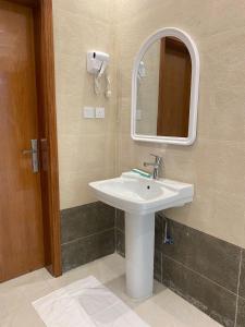 W łazience znajduje się umywalka i lustro. w obiekcie قمم بارك Qimam Park Hotel 2 w mieście Abha