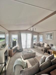 ein Wohnzimmer mit einem Sofa und einem TV in der Unterkunft Norfolk Caravan Staycation Pet Friendly in Belton