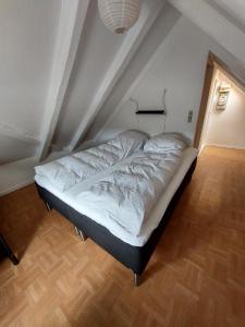uma pequena cama num quarto com tecto em Turf House Cottage - Near Airport em Miðvágur