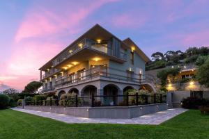 a large house with a sunset in the background at Villa LeA in Imperia