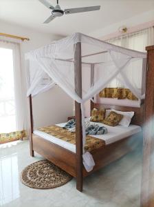 a bedroom with two bunk beds and a ceiling at Zanzicrown in Nungwi