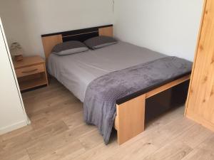 1 dormitorio con 1 cama y suelo de madera en Maison au carrefour des terroirs 