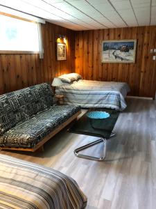 um quarto com duas camas, um sofá e uma mesa em Fanny et Maxime em Gatineau