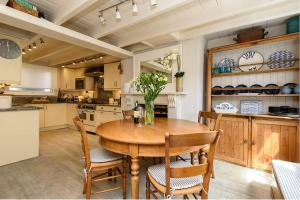 eine große Küche mit einem Holztisch und Stühlen in der Unterkunft Beautiful 3 bedroom cottage in the heart of Looe in Looe