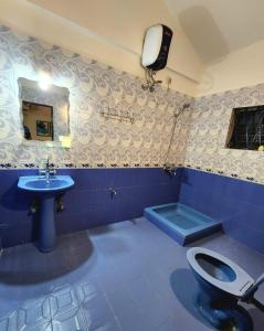 a bathroom with a blue toilet and a sink at Casa Casita Candolim in Candolim