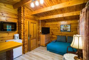 a living room with a blue couch in a log cabin at Leśny Dworek in Darłowo