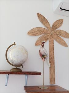 a toy bird sitting on a table next to a palm tree at Zanzicrown in Nungwi