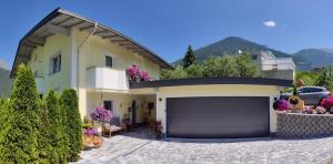 a house with a garage and a driveway at Apart Almrausch in Nauders