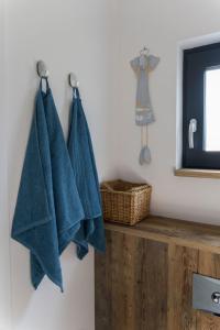 a bathroom with blue towels hanging on a wall at Domki Czarny Bocian in Białogóra