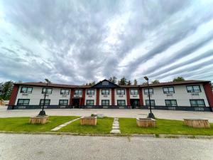 a large building with three benches in front of it at HWY 17 Hotel in Wawa
