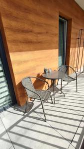 2 Stühle und ein Tisch auf der Terrasse in der Unterkunft Apartament KoraZone 2 ZATOR in Zator