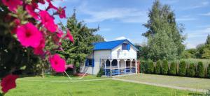 a small white house with a blue roof at Karsibór DE in Świnoujście