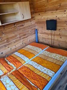 a large bed in a room with a wooden wall at u Anny Pionierów 8B in Mielno