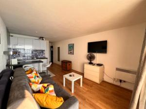 a living room with a couch and a flat screen tv at L'océan à perte de vue, la grande plage à vos pieds in Biarritz