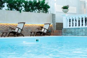 two chairs sitting next to a swimming pool at Armata Boutique Hotel in Spetses