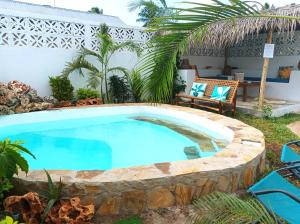 a swimming pool in a yard with a patio furniture at Zanzicrown in Nungwi