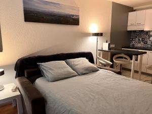 um quarto com uma cama, uma mesa e uma cozinha em L'océan à perte de vue, la grande plage à vos pieds em Biarritz
