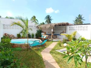 a backyard with a swimming pool and a house at Zanzicrown in Nungwi