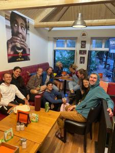 eine Gruppe von Personen, die in einem Zimmer sitzen in der Unterkunft Room Mate Hostel Amsterdam Zaandam in Zaandam