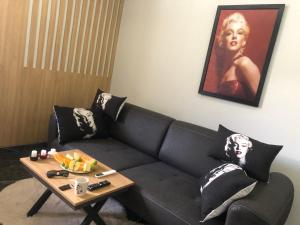 Sofya Suites في فتحية: غرفة معيشة مع أريكة سوداء وطاولة