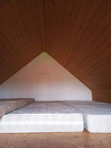 ein großes Bett in einem Zimmer mit Holzdecke in der Unterkunft Sklep U Petra in Velké Bílovice