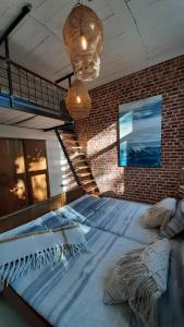 a large bed in a room with a brick wall at Apartament Old School in Ustronie Morskie