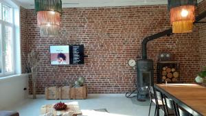 a kitchen with a brick wall and a stove at Apartament Old School in Ustronie Morskie
