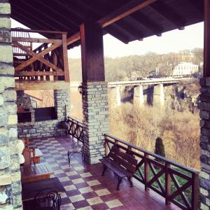 a balcony with benches and a view of a bridge at Guesthouse Grand Canyon in Kamianets-Podilskyi