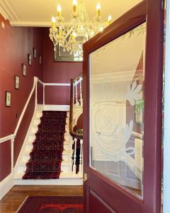 a hallway with red walls and a chandelier at 38 St Giles in Norwich