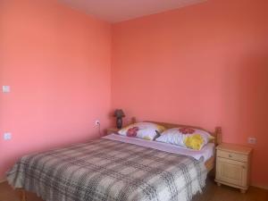 1 dormitorio con cama y pared de color rosa en Studio Fatinia en Byala