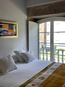 1 dormitorio con 1 cama blanca grande y ventana en Exclusivo apartamento en edificio de lujo, en Mondariz-Balneario