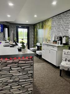 a kitchen with a stone wall and a table and chairs at HWY 17 Hotel in Wawa