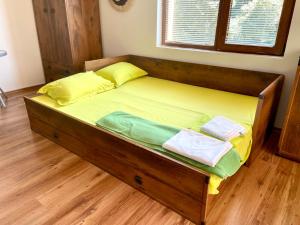 a wooden bed with two towels on it in a room at ART Apartments - Pomorie in Pomorie +23 photos