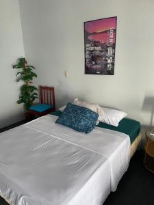 Un dormitorio con una cama blanca y un cuadro en la pared. en Playa El Obispo D La Marea building La Libertad, en La Libertad