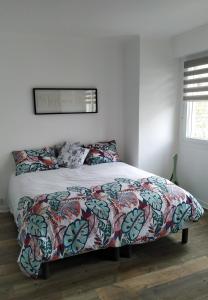 - une chambre avec un lit et une couverture colorée dans l'établissement Magnifique Vue mer pour ce T2 totalement rénové classé meublé de tourisme 3 etoiles, à Dunkerque