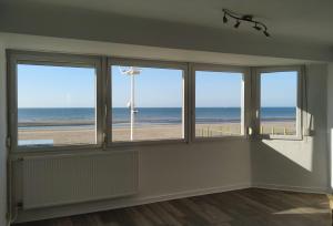 Cette chambre dispose de fenêtres offrant une vue sur la plage. dans l'établissement Magnifique Vue mer pour ce T2 totalement rénové classé meublé de tourisme 3 etoiles, à Dunkerque